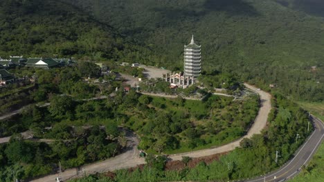 Antena-Dando-Vueltas-Alrededor-De-La-Estatua-Alta-De-Buda-Y-La-Torre-Del-Templo-Con-Enormes-Montañas-Y-Océano-En-Da-Nang,-Vietnam