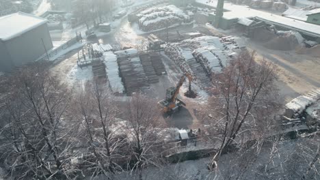 Aerial-view-of-sawmill-and-cranes-loading-tree-logs-in-winter-season
