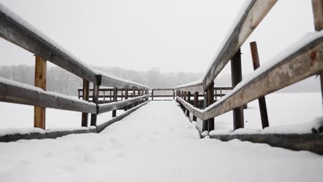 Flachschuss-Einer-Schneebedeckten-Brücke-Auf-Einem-Zugefrorenen-See-An-Einem-Verschneiten-Wintertag