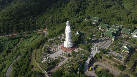 Antena-De-La-Estatua-Más-Alta-De-Buda-Y-Templos-Con-Enormes-Montañas-Y-Océano-En-Da-Nang,-Vietnam