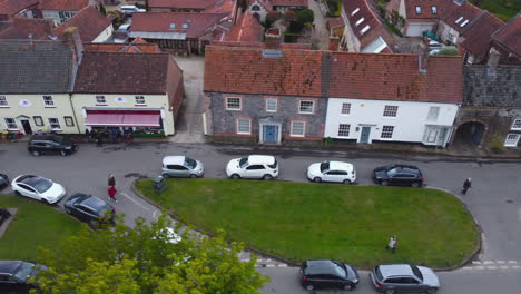 Sideways-Slider-Aerial-Drone-Shot-of-Beautiful-Old-Village-Burnham-Market-Shops-and-Houses-on-Sunny-and-Cloudy-Day-North-Norfolk-UK