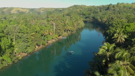 reveal-aerial-drone-shot-from-a-local-filipino-boat-on-the-Loboc-River-surrounded-by-palmtrees-and-green-forest-on-Bohol-Island-in-the-philippines-during-sunset