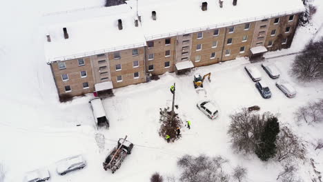 Electricity-pole-replacement-for-an-apartment-building-in-winter,-aerial-view