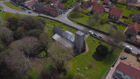 High-Rotating-Aerial-Drone-Shot-Around-Old-Church-in-Beautiful-Village-with-Houses-and-Trees-on-Sunny-Day-in-Burnham-Market-North-Norfolk-UK