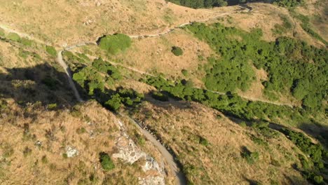 Aerial-clip-of-a-biker-while-biking-on-a-trail-near-a-big-city-in-New-Zealand