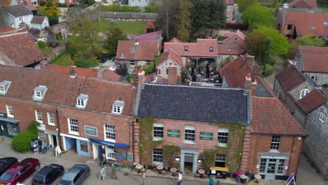 Sideways-Slider-Aerial-Drone-Shot-of-Beautiful-Old-Village-Burnham-Market-Shops-and-Houses-on-Sunny-and-Cloudy-Day-North-Norfolk-UK
