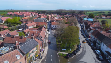 Aerial-Drone-Shot-Flying-Down-Beautiful-Old-Burnham-Market-Village-Main-Road-on-Sunny-and-Cloudy-Day-in-Burnham-Market-North-Norfolk-UK