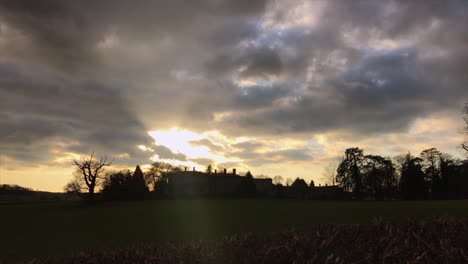 Spooky-Leicestershire-Manor-House-sun-setting-behind-creating-a-silhouette-with-dark-swirling-clouds