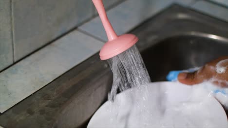 Asian-hands-washing-dishes-using-foam-sponges