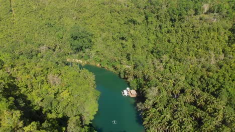 4k-aerial-pan-drone-shot-from-a-river-in-Asia-in-the-middle-of-the-jungle-slowly-revealing-a-small-local-boat-on-the-river-during-golden-hour