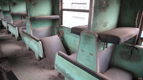Inside-an-old-rusty-train-with-a-lot-of-broken-passenger-seats