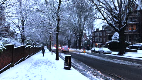 Snowy-London-city-scene-person-walking-down-street-past-traffic
