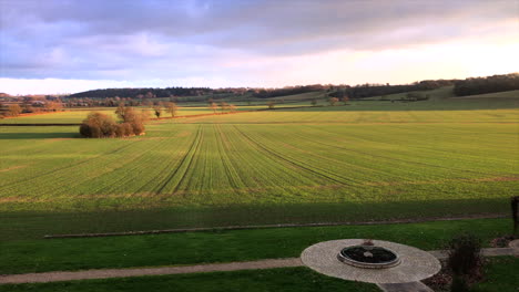 Leicestershire-Manor-House-view-over-field-and-courtyard-with-green-paddock-and-blue-pink-skies-during-day-diagonal-angle