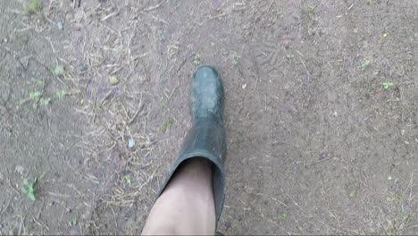 POV-of-a-man-wearing-black-boots-walking-looking-down-on-a-muddy-road
