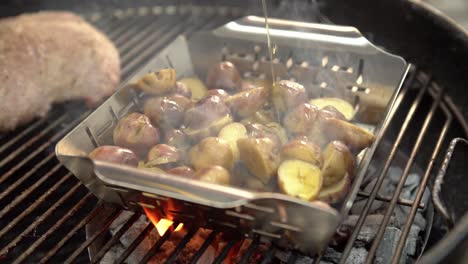 Chef-drizzling-olive-oil-over-potatoes-on-a-hot-grill-with-pork-beef,-slow-motion