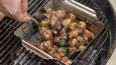 Close-up,-Chef-stirring-grilled-and-seasoned-potatoes-over-a-hot-grill,-slow-motion