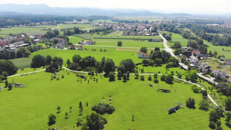 Wide-angle-Dolly-in-aerial-Shot-of-Volcji-Potok-Arboretum-and-the-surrounding-landscapes-during-the-day
