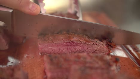 Chef-cutting-juicy-medium-rare-flank-beef,-slow-motion