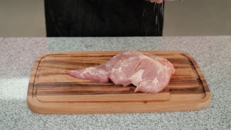 Closeup-of-a-chef-adding-salt-to-a-raw-pork-beef