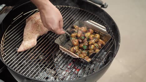 Chef-stirring-grilled-and-seasoned-potatoes-over-a-hot-grill,-slow-motion