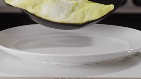 placing-an-omelette-onto-a-white-plate