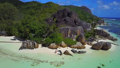 Couple-kisses-on-tropical-and-famous-Anse-Source-d'Argent,-La-Digue,-Seychelles