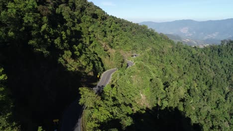 AERIAL-Winding-Road-Amongst-Lush-Mountain-Tropical-Forest