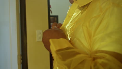 Elder-Filipino-Man-Buttoning-Yellow-Barong-in-His-Room