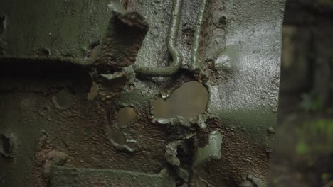 Closeup-pivoting-shot-of-bullet-holes-in-a-bunker-door-on-Corregidor-Island