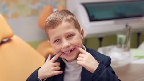 Closeup-Portrait,-Kleiner-Junge-Zeigt-Mit-Dem-Finger-Auf-Seine-Gesunden-Zähne-In-Der-Zahnarztpraxis