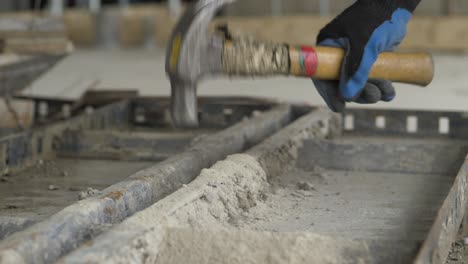 Close-up-of-a-hammer-hitting-concrete-on-a-metal-structure,-slow-motion