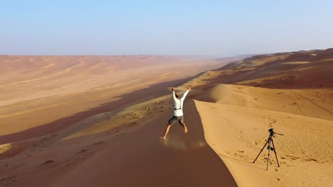 A-man-taking-a-self-timer-photo-alone-in-the-desert,-Oman