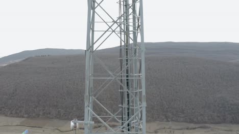 Tall-Telecommunication-Steel-Mast-With-Ladder-Built-In-Kaspi,Georgia-Overlooking-The-Wide-Field-Under-The-Dramatic-Sky---Aerial-Shot