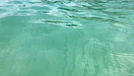 Sea-ripples-of-transparent-pristine-clear-cyan-water-and-seabed-in-4k