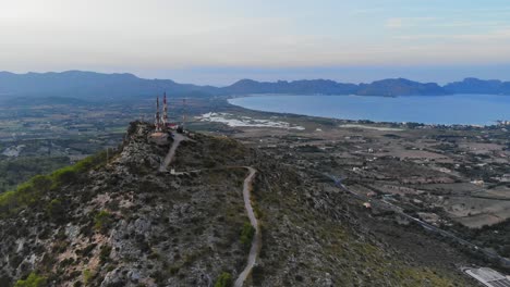 Drone-view-of-communications-towers-atop-a-small-mountain-in-Mallorca,-Spain