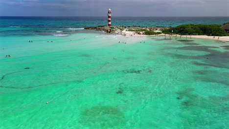 Aerial-drone-footage-over-a-blow-up-climbing-structure,-a-kayaker,-and-people-relaxing-on-a-sandbar,-in-the-turquoise-waters,-along-the-coast-of-the-Hyatt-Ziva-in-Cancun-Mexico