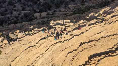 A-top-shot-of-a-group-of-people-sightseeing-on-a-cliff,-Oman