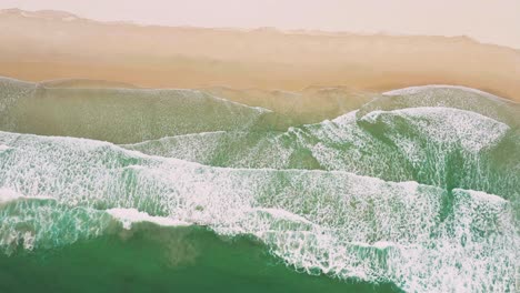Luftaufnahmen-Vom-Fliegen-über-Einen-Atemberaubenden-Sandstrand-Mit-Tropischen-Wellen,-Die-In-Die-Küste-Rollen