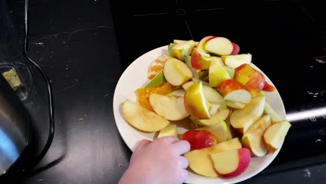 Draufsicht-In-Zeitlupe,-Kind-Nimmt-Apfelscheiben-Vom-Weißen-Teller,-Kleine-Hand-Mit-Früchten