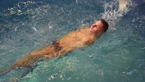 sports-guy-in-spa-swims-in-pool-on-back