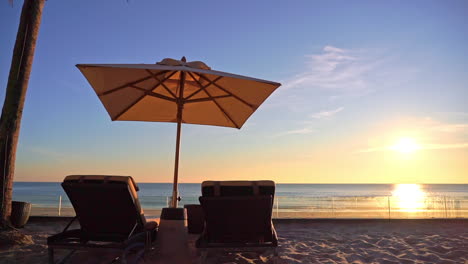 Zwei-Liegestühle-Unter-Sonnenschirm-Am-Tropischen-Strand-Bei-Sonnenuntergang