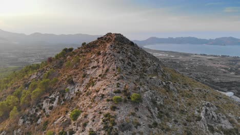 Luftdrohne-Nähert-Sich-Einem-Natürlichen-Berggipfel-Mit-Ozean-Im-Hintergrund,-Spanien
