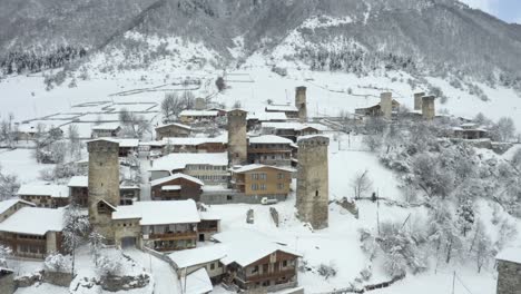 Houses-Surrounded-By-Cold-White-Snow-In-Mestia,-Svaneti,-Georgia-During-Winter-Season---Aerial-Shot
