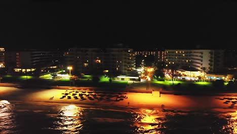 Drone-tracking-shot-of-empty-beach-resort-at-nighttime,-in-Mallorca,-Spain