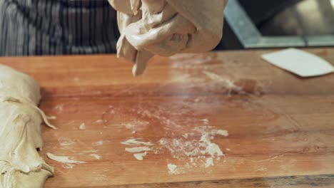 the-baker-kneads-the-wet-dough-on-the-board