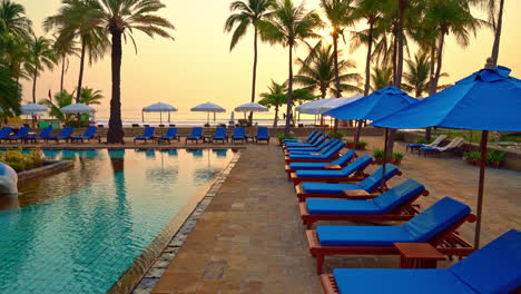 beautiful-palm-tree-with-umbrella-chair-pool-in-luxury-hotel-resort-at-sunrise-times