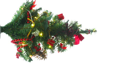 Weihnachtlich-Geschmückter-Kleiner-Baum-Mit-Roten-Und-Goldenen-Dekorationen-Leuchtet-Langsam-Eine-Leichte-Kette-Auf,-Die-Um-Einen-Baum-Aus-Gelben-Farblichtern-In-Zeitlupenaufnahme-Gewickelt-Ist