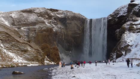 Tourists-admiring-Skogafoss-waterfall-in-south-Iceland-in-winter