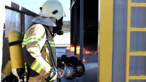 Feuerwehrmann-Löscht-Feuer-Auf-Industriegelände,-über-Die-Schulter