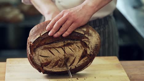 closeup,-baker's-hands-cut-home-made-rye-bread